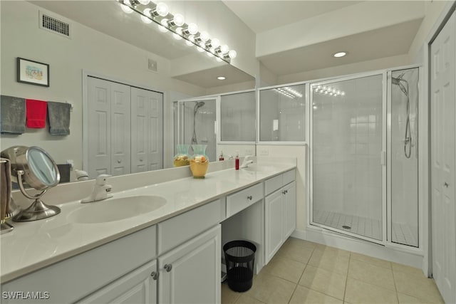 bathroom with vanity, a shower with door, and tile patterned floors