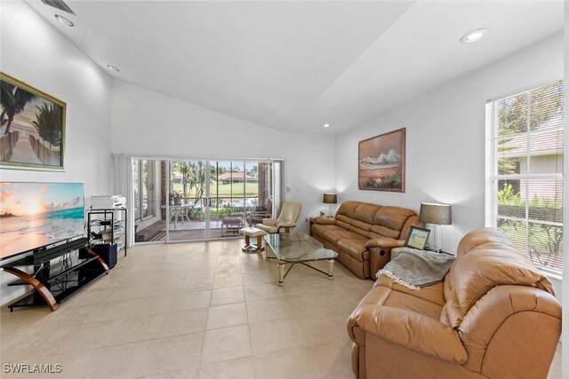 tiled living room with high vaulted ceiling and a wealth of natural light