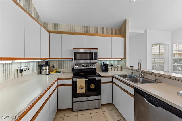 kitchen featuring stainless steel appliances, white cabinetry, and sink