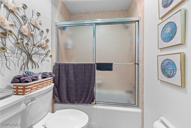 bathroom with toilet and enclosed tub / shower combo