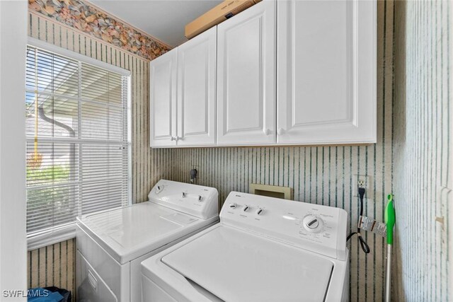 laundry area with independent washer and dryer, cabinets, and a healthy amount of sunlight