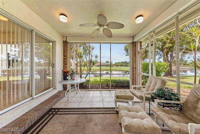 sunroom / solarium with a water view and ceiling fan