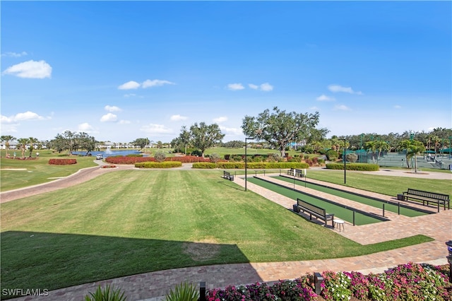 view of property's community featuring a lawn and a water view