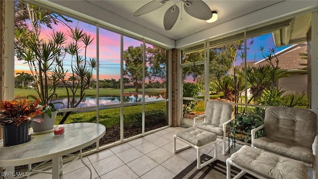 sunroom / solarium featuring a water view and a ceiling fan