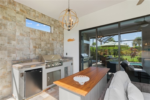 view of patio featuring ceiling fan, a lanai, grilling area, and an outdoor kitchen