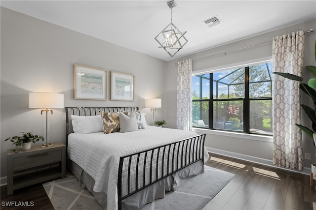 bedroom featuring dark hardwood / wood-style floors and a chandelier