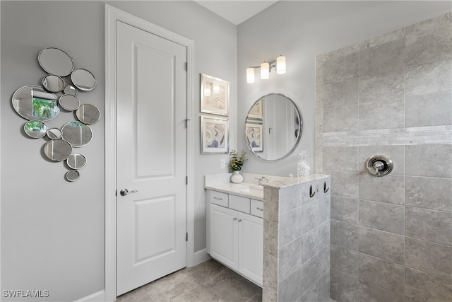 bathroom featuring vanity, tiled shower, and tile patterned flooring