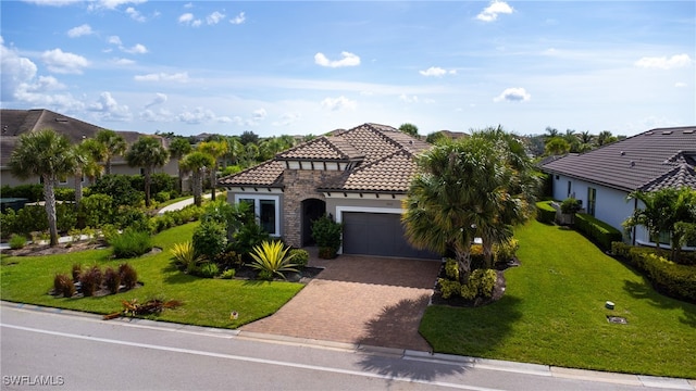 mediterranean / spanish home featuring a front yard and a garage