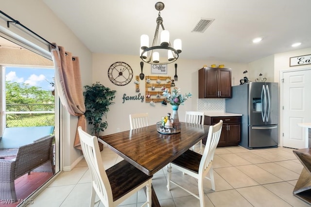 tiled dining area featuring an inviting chandelier