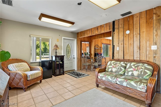 living room with light tile patterned flooring and wood walls