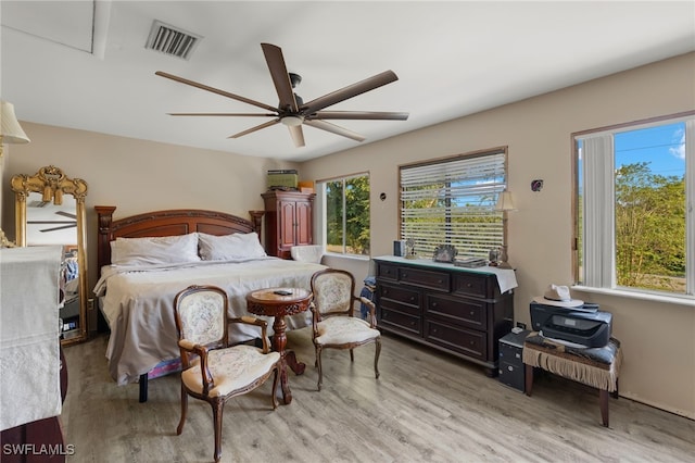 bedroom featuring light hardwood / wood-style floors, multiple windows, and ceiling fan