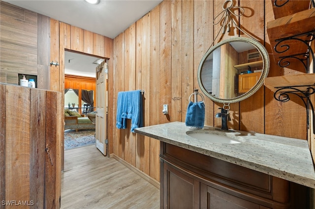 interior space featuring vanity, wooden walls, and hardwood / wood-style floors