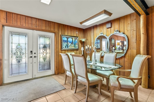 tiled dining area featuring french doors and wood walls