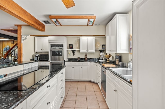 kitchen with dark stone counters, light tile patterned flooring, white cabinetry, and stainless steel appliances