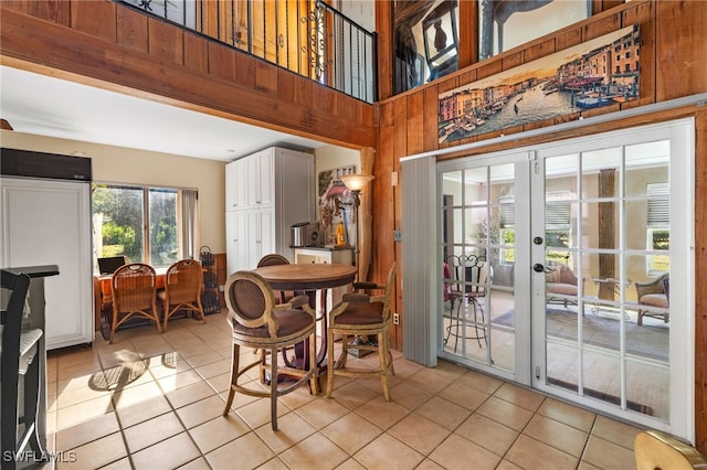 tiled dining space with a towering ceiling and french doors