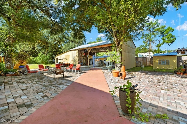 view of patio / terrace with a storage unit and an outdoor fire pit