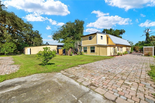 view of front of home with an outdoor structure and a front yard