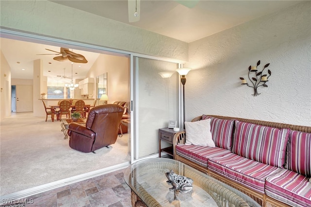 carpeted living room with ceiling fan and vaulted ceiling