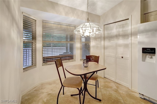 tiled dining room featuring an inviting chandelier