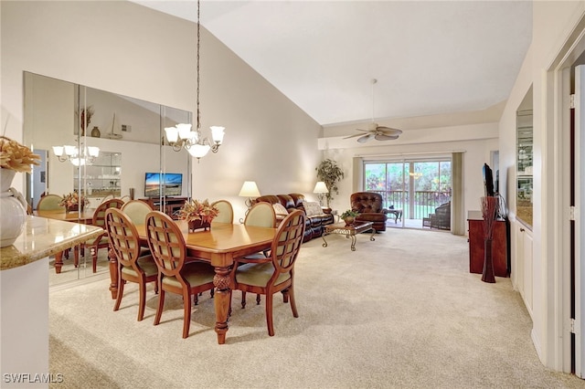 carpeted dining area featuring high vaulted ceiling and ceiling fan with notable chandelier