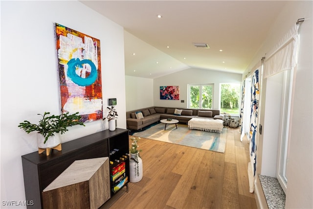 living room featuring light wood-type flooring and vaulted ceiling