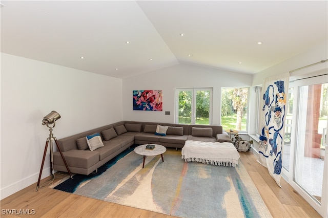 living room featuring vaulted ceiling and light hardwood / wood-style flooring