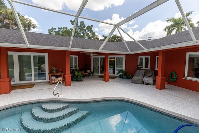 view of swimming pool with a patio, a lanai, and ceiling fan