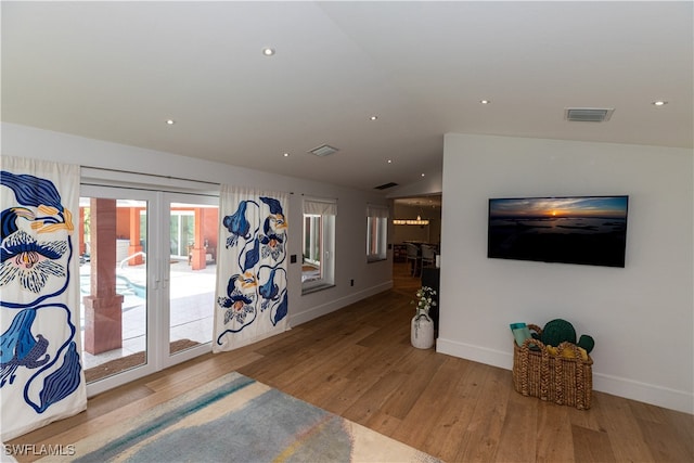 foyer with lofted ceiling, light hardwood / wood-style flooring, and french doors