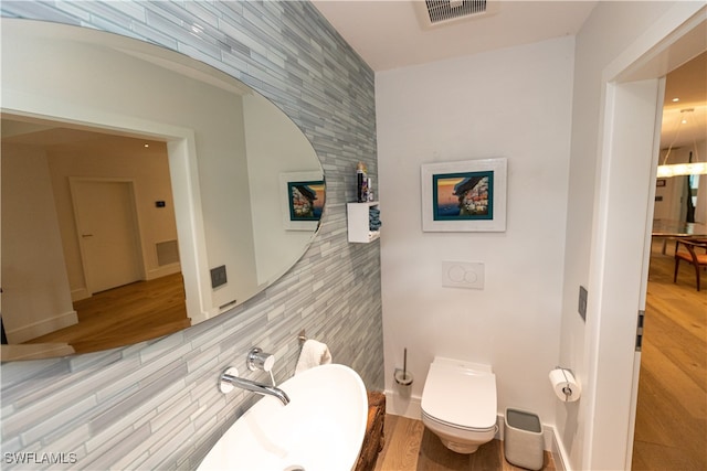 bathroom with hardwood / wood-style flooring and toilet