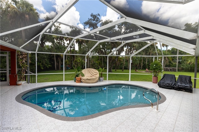 view of swimming pool with a patio, a yard, and a lanai