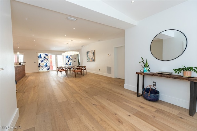 interior space with light hardwood / wood-style flooring and a notable chandelier