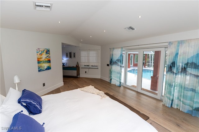 bedroom with light wood-type flooring, lofted ceiling, and access to exterior