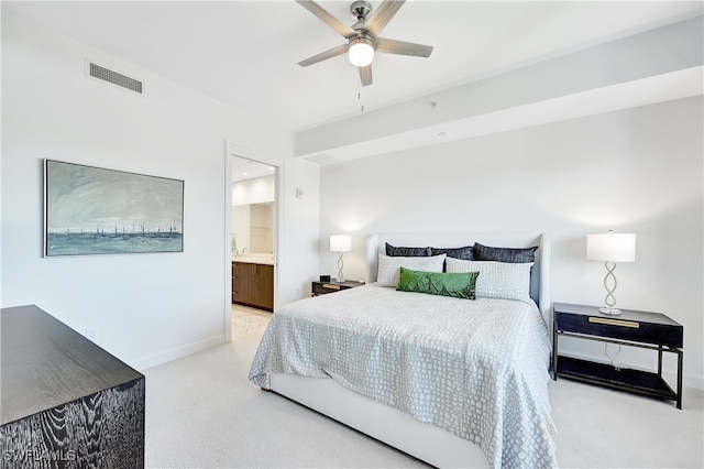 carpeted bedroom with ensuite bath and ceiling fan