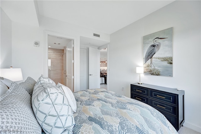 bedroom with ensuite bathroom and carpet