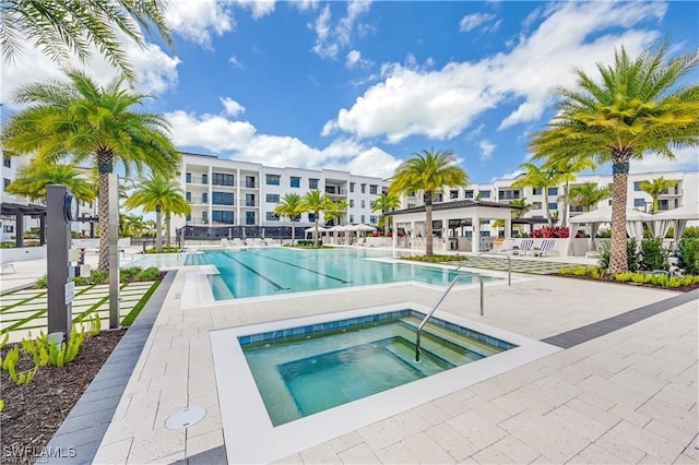 view of swimming pool featuring a patio and a hot tub