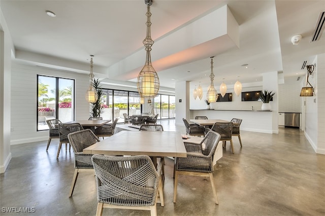 dining space with an inviting chandelier and concrete flooring