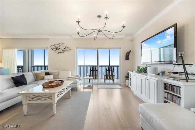 living room featuring a wealth of natural light, an inviting chandelier, ornamental molding, and light wood-type flooring