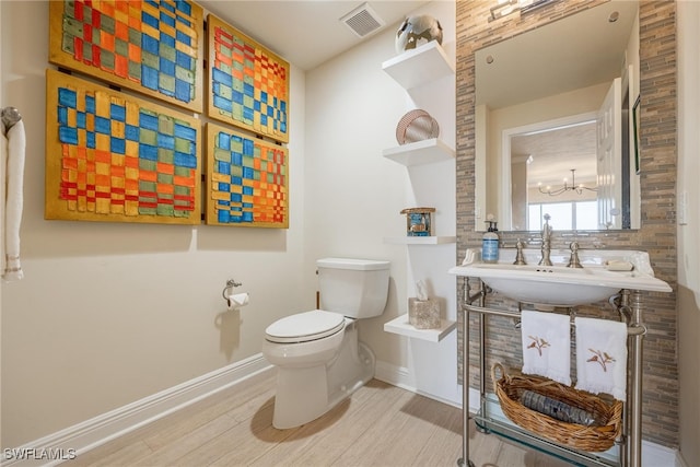 bathroom with decorative backsplash, toilet, wood-type flooring, and sink