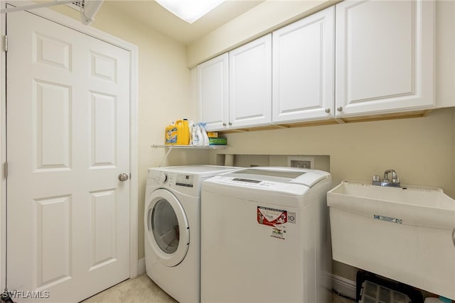 laundry room with washer and clothes dryer, sink, and cabinets