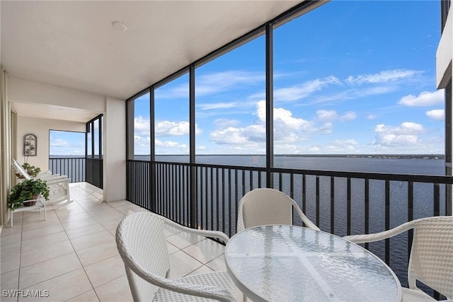 sunroom featuring a water view