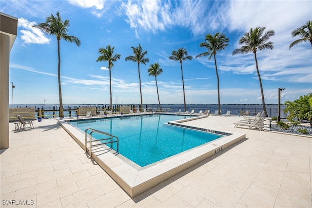 view of swimming pool with a patio area and a water view