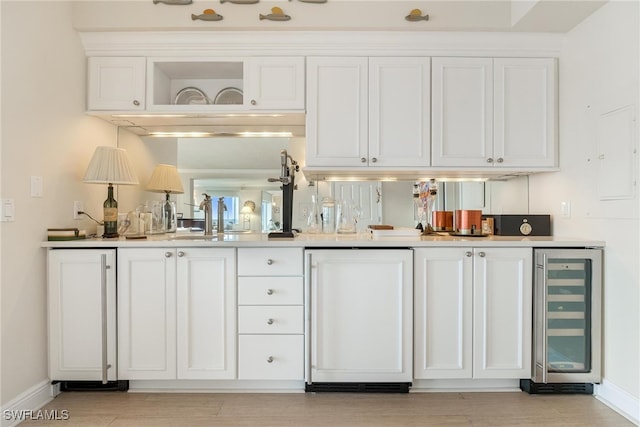 bar with wine cooler, white cabinetry, sink, and white refrigerator