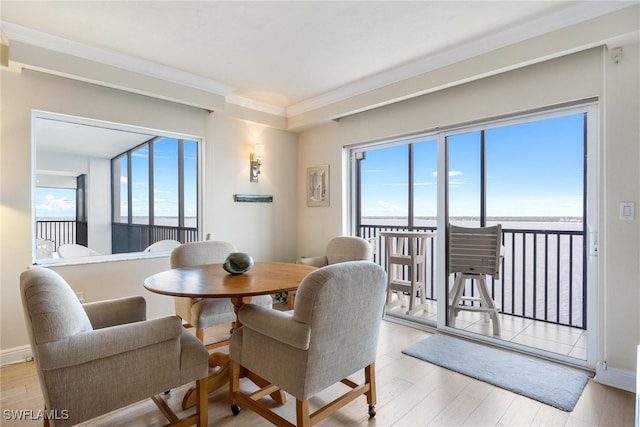 dining space with plenty of natural light, ornamental molding, and light hardwood / wood-style flooring