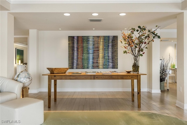 interior space with hardwood / wood-style floors and ornamental molding