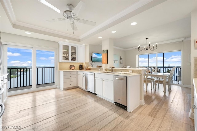 kitchen featuring white cabinets, decorative light fixtures, kitchen peninsula, and light hardwood / wood-style floors