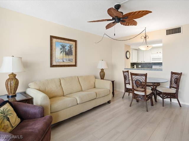 living room featuring ceiling fan and light wood-type flooring