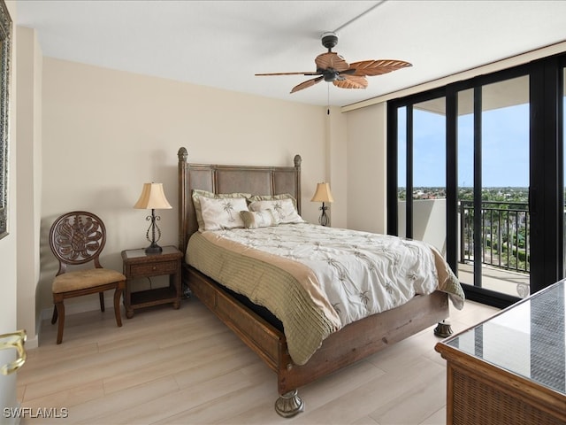 bedroom featuring light wood-type flooring, access to outside, a wall of windows, and ceiling fan