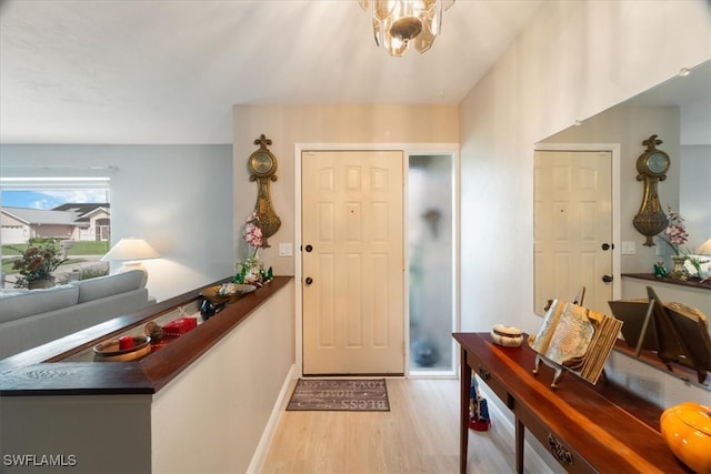 foyer entrance featuring light hardwood / wood-style floors and a chandelier