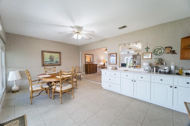 tiled dining room with sink and ceiling fan