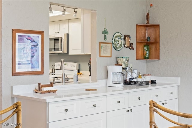 kitchen with white cabinets and white stove